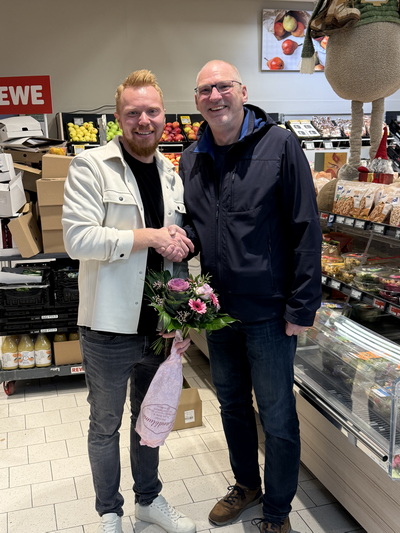 Ortsvorsteher Fred Witschel überbringt Glückwünsche zur Neueröffnung an REWE-Inhaber Phillipp Fischer